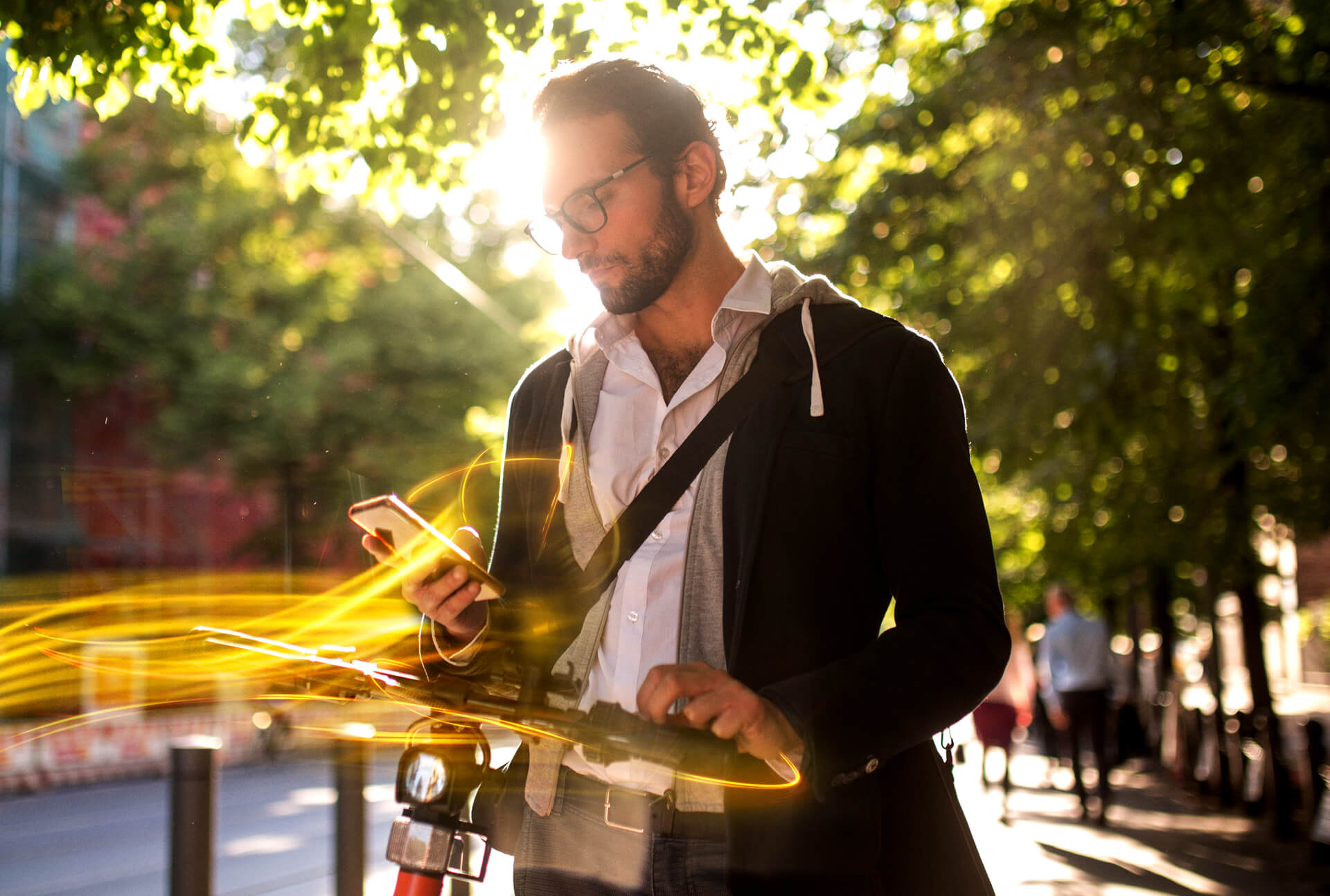 männliche Person mit Smartphone am E-Scooter