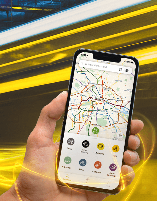 Hand holding a smartphone showing the Jelbi app, a streetcar is passing by in the background