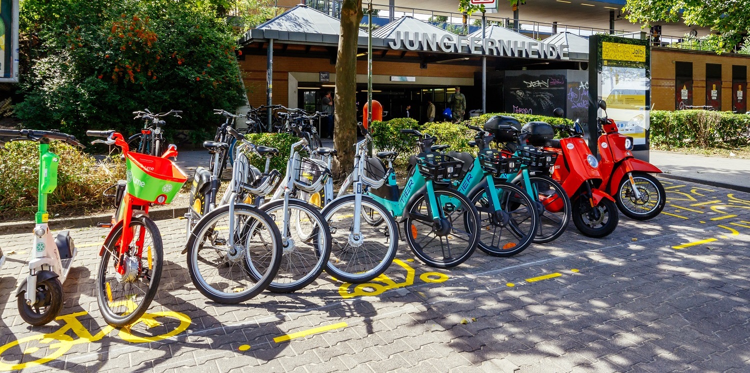 Eine Jelbi-Mobilitätsstation and dem Bahnhof S+U Jungfernheide an dem Sharing-Fahrzeuge bereitstehen